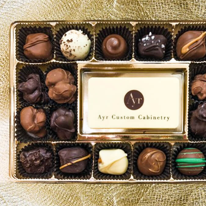 Box of assorted chocolates with a visible brand label on a gold background