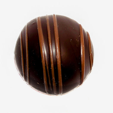 Chocolate truffle with brown stripes on a white background