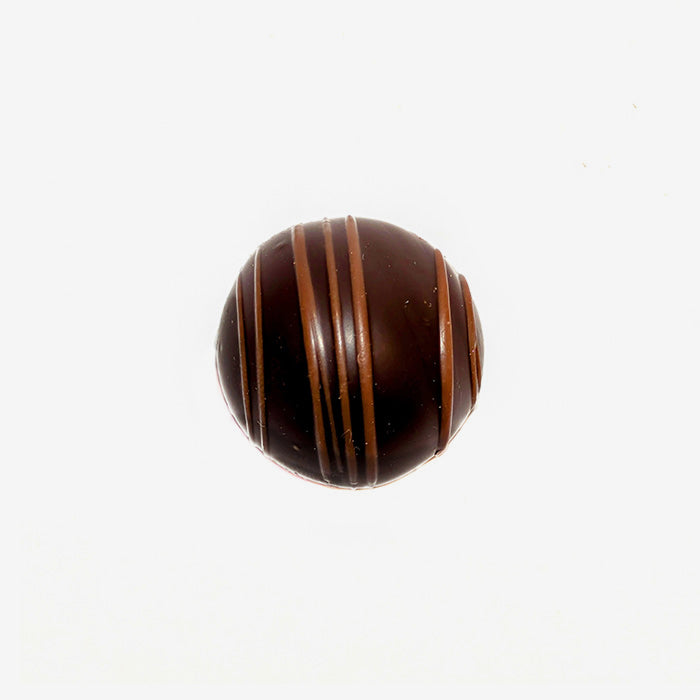 Chocolate truffle with brown stripes on a white background