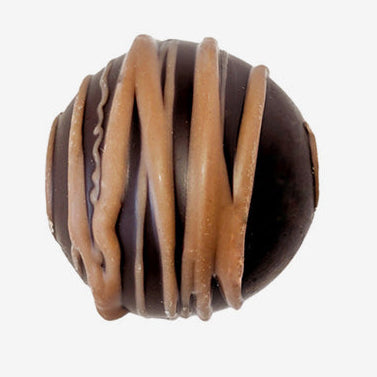 Chocolate truffle with caramel drizzle on a white background