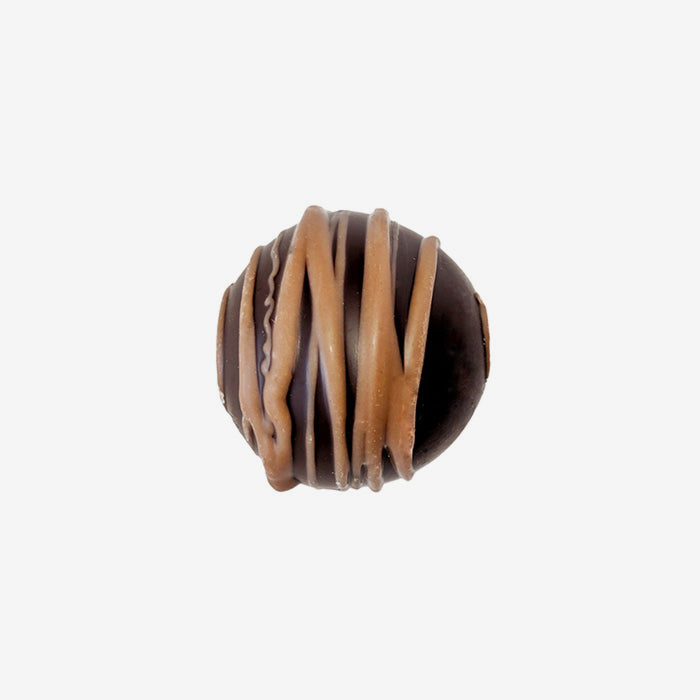 Chocolate truffle with caramel drizzle on a white background