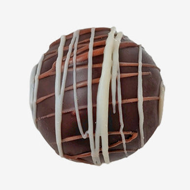 Chocolate truffle with white drizzle on a white background