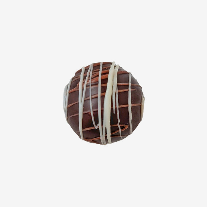 Chocolate truffle with white drizzle on a white background