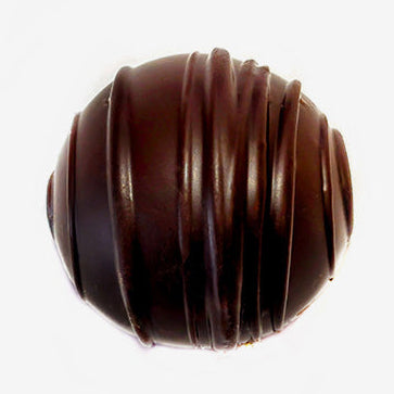 Chocolate truffle with a ribbed texture on a white background