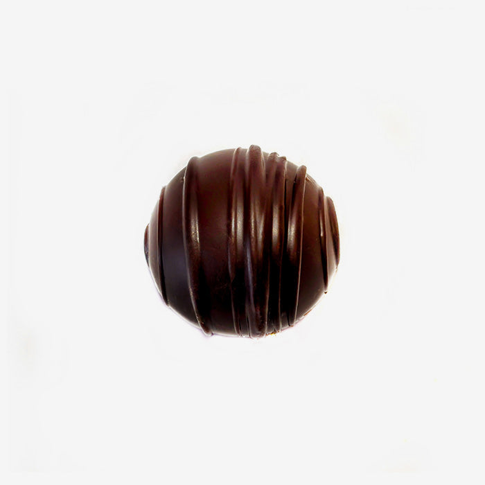 Chocolate truffle with a ribbed texture on a white background