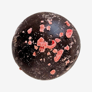 Chocolate truffle with red sprinkles on a white background