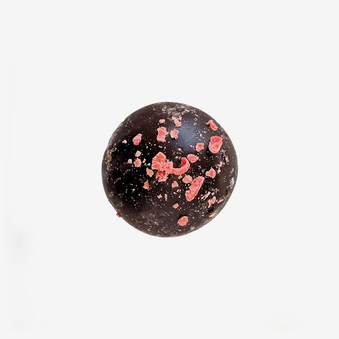 Chocolate truffle with red sprinkles on a white background