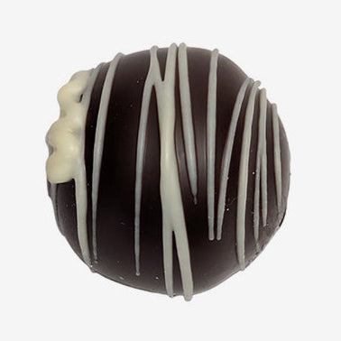 Chocolate truffle with white drizzle on a white background