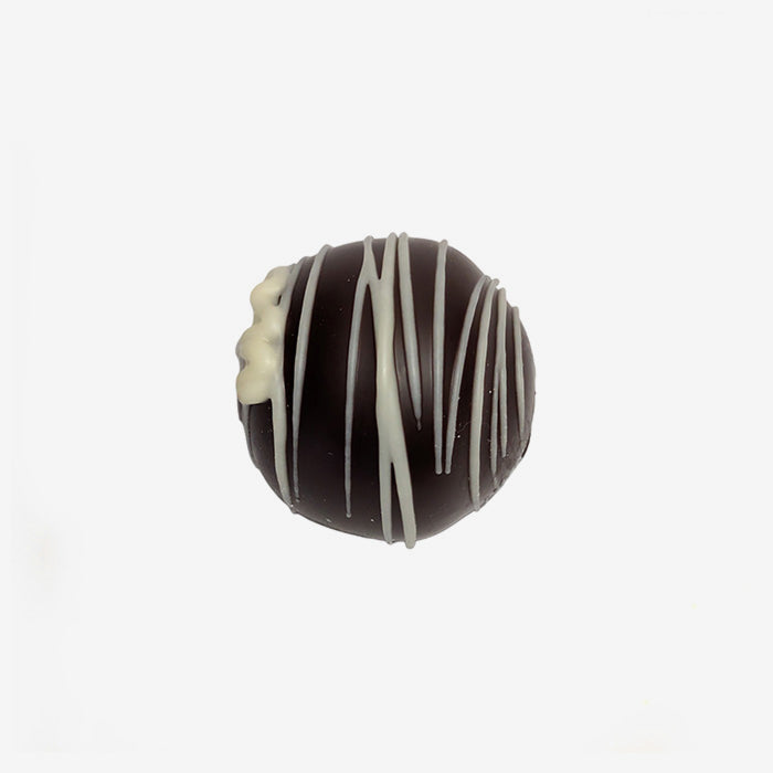 Chocolate truffle with white drizzle on a white background