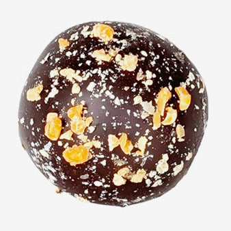 Chocolate truffle with gold flakes on a white background