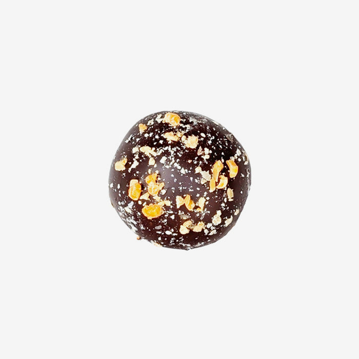 Chocolate truffle with gold flakes on a white background