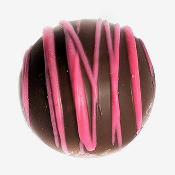 Chocolate truffle with pink drizzle on a white background