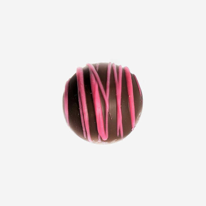 Chocolate truffle with pink drizzle on a white background