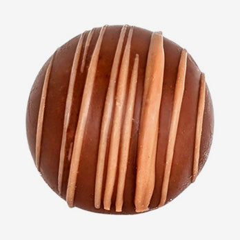 Chocolate truffle with drizzle pattern on a white background