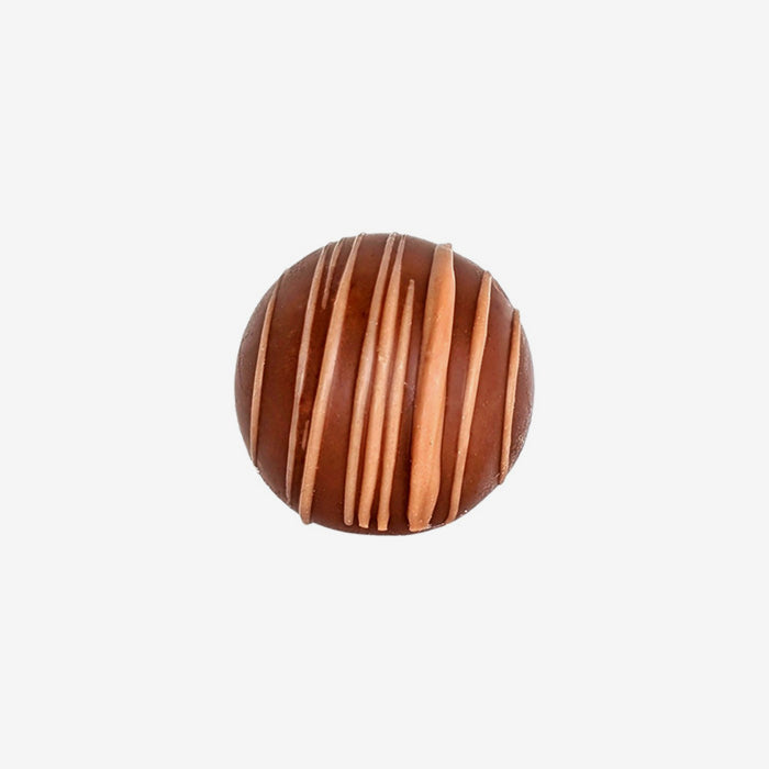 Chocolate truffle with drizzle pattern on a white background
