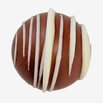 Chocolate truffle with white drizzle on a white background