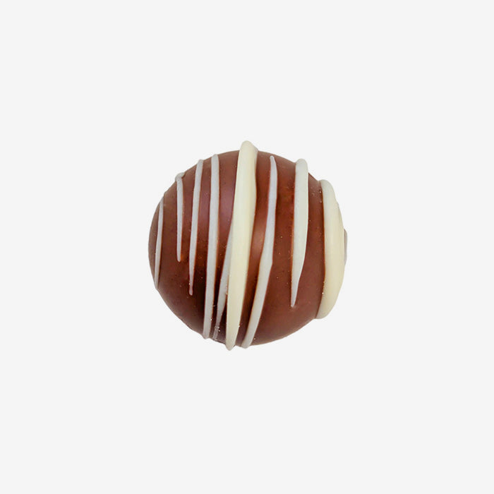 Chocolate truffle with white drizzle on a white background
