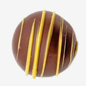 Chocolate truffle with yellow stripes on a white background