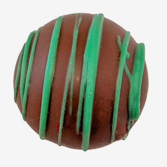 Chocolate truffle with green drizzle on a white background