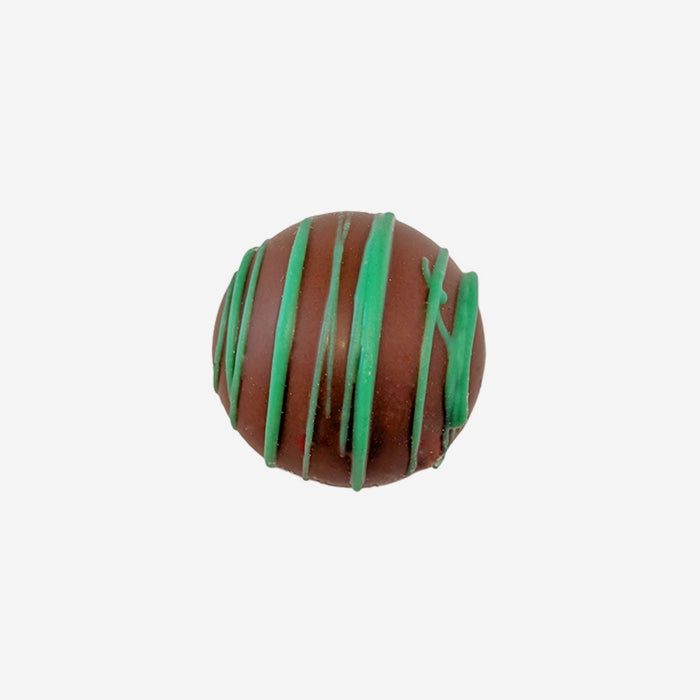 Chocolate truffle with green drizzle on a white background