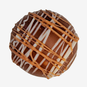 Chocolate truffle with caramel drizzle on a white background
