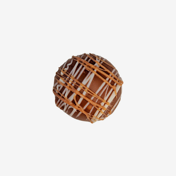 Chocolate truffle with caramel drizzle on a white background