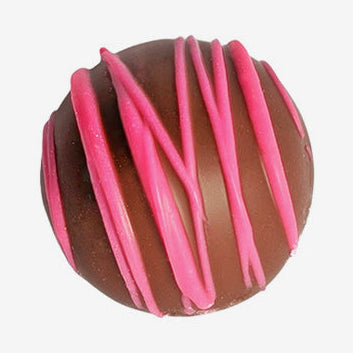 Chocolate truffle with pink drizzle on a white background