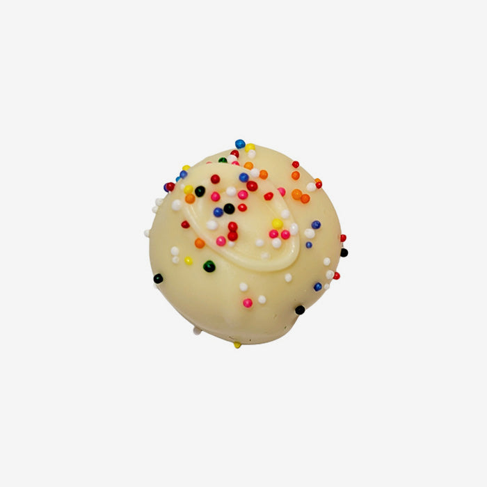 White chocolate truffle with white icing and colorful sprinkles on a white background