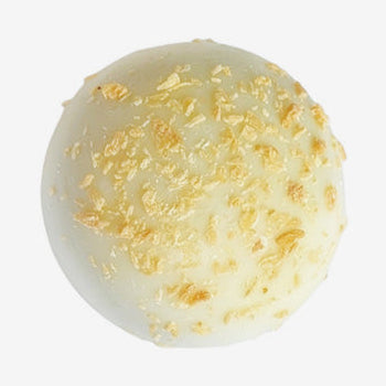 White chocolate truffle with gold sprinkles on a white background