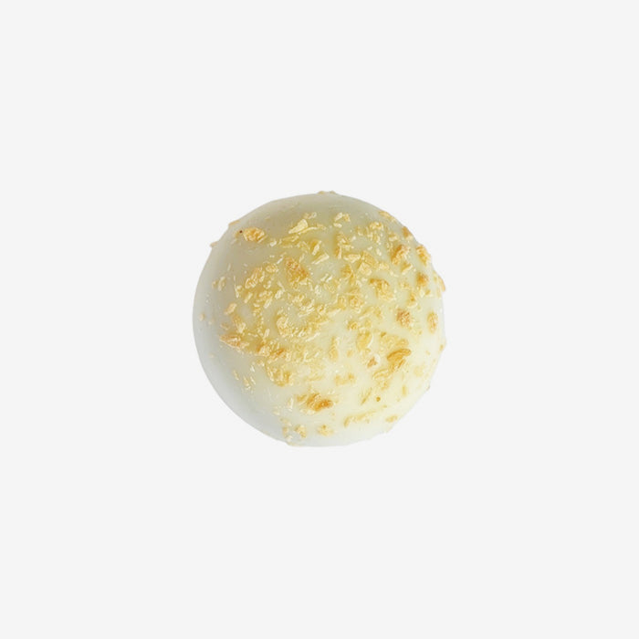White chocolate truffle with gold sprinkles on a white background