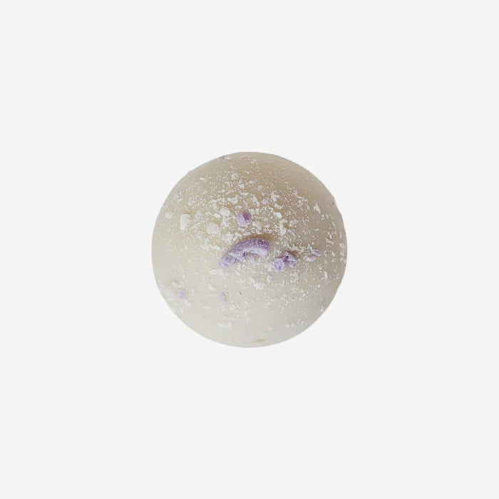 Round bath bomb with purple specks on a white background